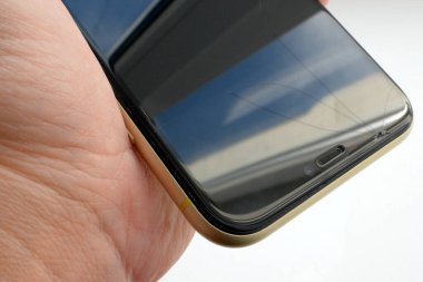 Elinde cam kırıkları olan telefon. Parçalanmış cep telefonlu kadın eli, yakın plan.