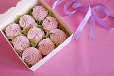 İçinde renkli kurabiyeler, bir kutu Zefir, Zephyr ve çiçeklerle dolu beyaz bir kutu. Bir kutu zephyr. Şekerleme ve şakayık çiçeği. Üst görünüm