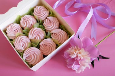 İçinde renkli kurabiyeler, bir kutu Zefir, Zephyr ve çiçeklerle dolu beyaz bir kutu. Bir kutu zephyr. Şekerleme ve şakayık çiçeği. Üst görünüm