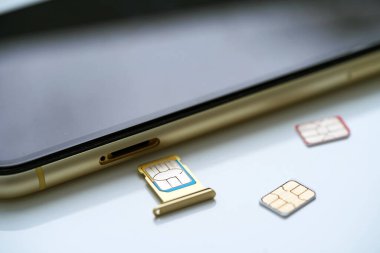 Modern cep telefonu arkaplanı yakınındaki renkli SIM kartlar, yakın plan