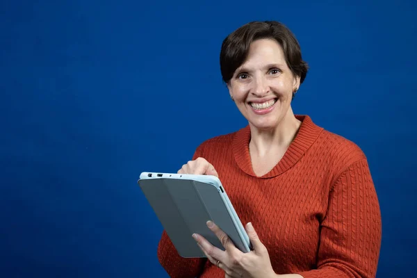 Een Vrouw Reageert Haar Reader Met Een Oranje Koudeweer Trui — Stockfoto