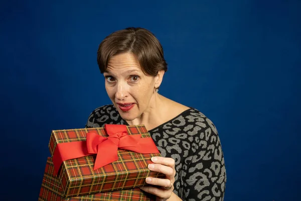 Oudere Vrouw Met Een Kerstcadeau Studio Met Blauwe Achtergrond — Stockfoto