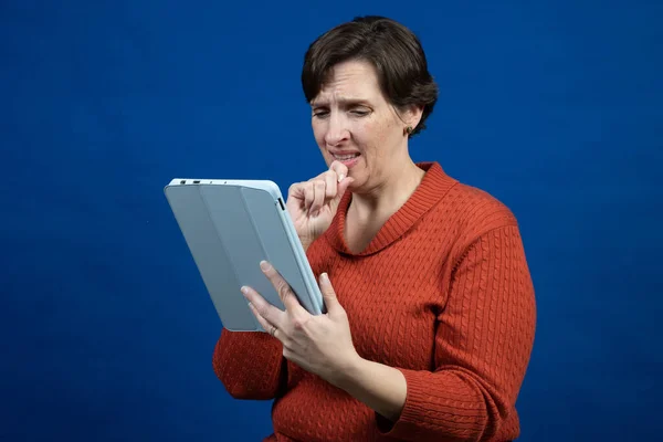 Een Vrouw Reageert Haar Reader Met Een Oranje Koudeweer Trui — Stockfoto
