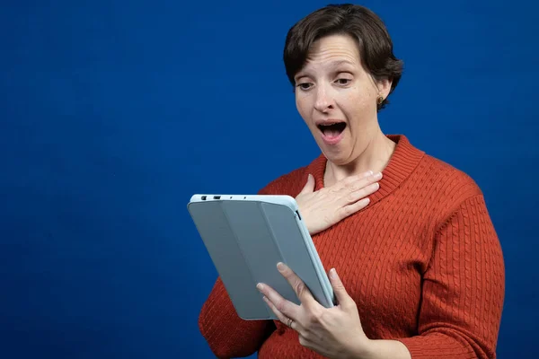 Una Mujer Reacciona Lector Electrónico Con Suéter Naranja Clima Frío — Foto de Stock