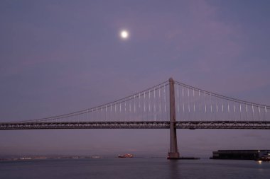 Oakland Bay köprüsü üzerinde ay doğuyor. Mavi saatte yüksek kaliteli fotoğraf.