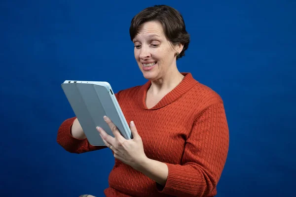 Uma Mulher Reage Seu Reader Vestindo Uma Camisola Laranja Fria — Fotografia de Stock