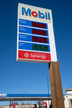 Lone Pine, CA, ABD - 9 Şubat 2023 - Mobil benzin istasyonu açık mavi gökyüzü ile Kaliforniya benzininin yüksek fiyatını gösteriyor