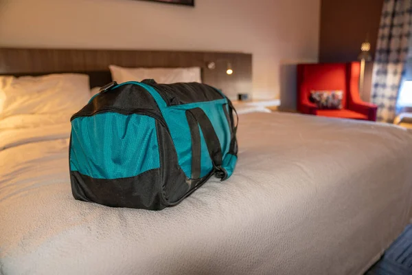 Stock image Shallow depth of field image of a small travel bag on the bed of a hotel room