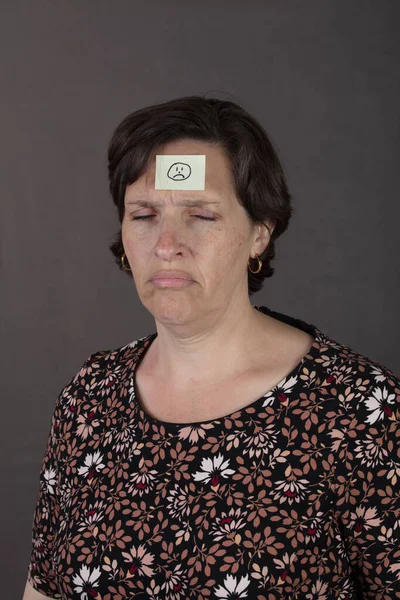 額に悲しい顔のステッカーで痛みの女性 高品質の写真 — ストック写真