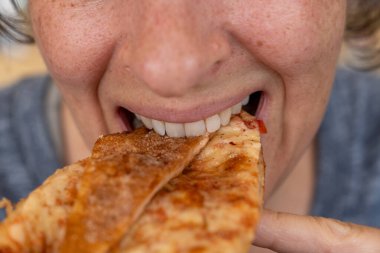 Mutlu orta yaşlı kadın bir dilim pizzanın tadını çıkarıyor. Yüksek kalite yakın çekim fotoğrafı.