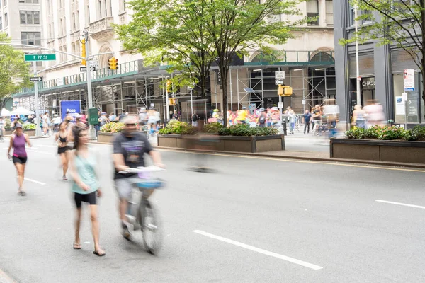 美国纽约 2023年8月12日 在曼哈顿一个温暖的夏日 自行车手和行人在公园大道享受开放的街道日 这张照片是用慢速快门速度拍摄的 以显示人们在运动 图库照片