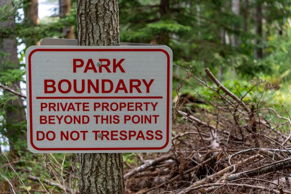 Park Boundary Sign. High-quality photo taken in a park in Maine showing the boundary of a park with private property on the other side.
