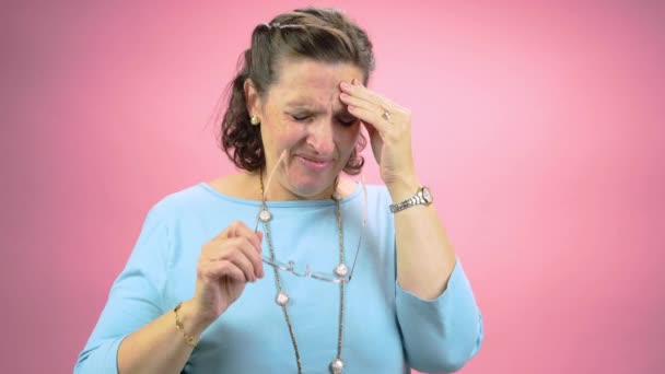 여성은 심각한 두통에 반응합니다 안경을 고통에 그녀의 머리와 문질러 여자의 — 비디오
