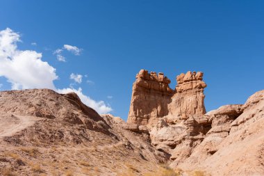 Çöl manzarası Utah 'ta parlak güneşli bir günde aşınmış kaya oluşumlarını ve kabadayıları gösteriyor.