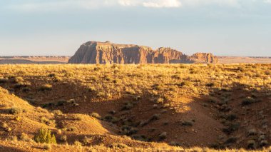 Çöl manzarası Utah 'ta parlak güneşli bir günde aşınmış kaya oluşumlarını ve kabadayıları gösteriyor.
