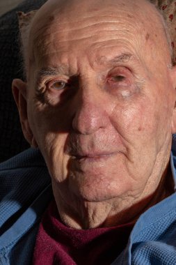 80 'li yaşların sonlarında yaşlı bir adam kameraya bakıyor. Bu yakın plan portrede, Strondg Directional Light' ta.