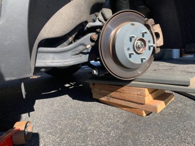 Ön tekerlek tahta bloklar üzerinde ev lastiği rotasyonu devam ediyor.