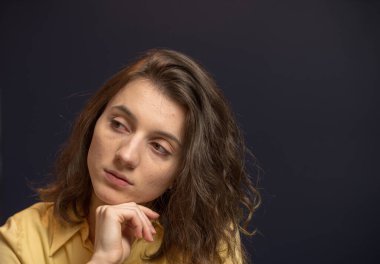 Koyu mavi duvarlar ile sarı gömlek yan düşünme arayan kadın