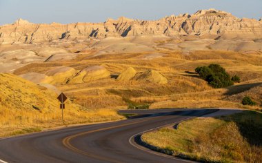 Arka planda dağ olan bir yol. Yol boş ve gökyüzü temiz.