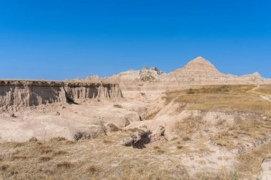 Üstünde küçük bir tepe olan büyük bir tepe. Tepe çorak ve kayalıktır. Gökyüzü mavi ve berrak
