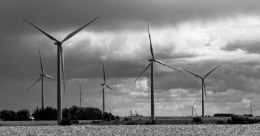Siyah ve beyaz rüzgar türbinleri, Minnesota kırsalında karamsar bulutlarla yüksek kontrastta