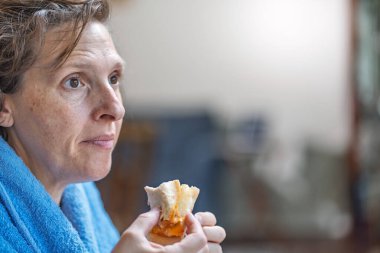 Orta Yaşlı ve Boyutlu Kadın Evde Rahatlarken Kahvaltı Sandviçi Keyfini Çıkartıyor