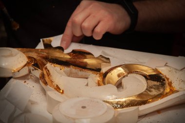 Siyah arka planda fırçası olan bir sanatçının elleri. Uzayı kopyala Altın kaplama sanatı