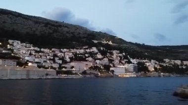 Deniz kenarındaki akşam kenti. Evlerin akşam ışıkları.
