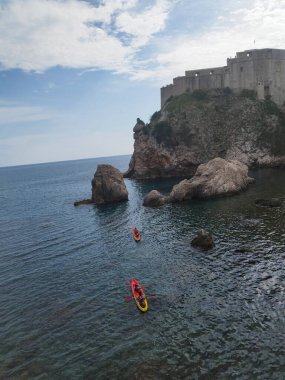 Denizde kayıklar. Kano sporu. Deniz Burnu. Kayadaki kale. Yaşlı Dubrovnik