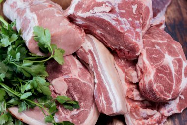 Tahta kesme tahtasında bir sürü taze domuz eti var.