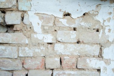 Kabuğu soyulmuş beyaz alçılı eski tuğla duvar