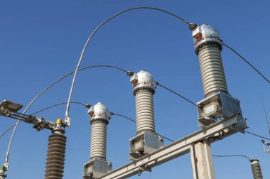 Part of high-voltage substation on blue sky background with switches and disconnectors. Ukrainian energy infrastructure.
