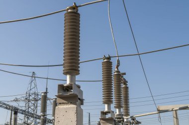 Part of high-voltage substation on blue sky background with switches and disconnectors. Ukrainian energy infrastructure.