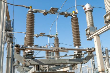 Part of high-voltage substation on blue sky background with switches and disconnectors. Ukrainian energy infrastructure.