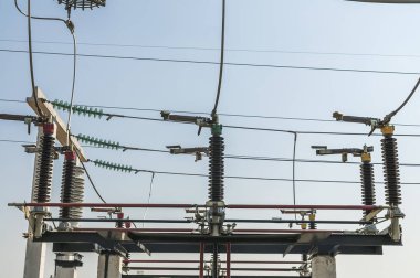 Part of high-voltage substation on blue sky background with switches and disconnectors. Ukrainian energy infrastructure.