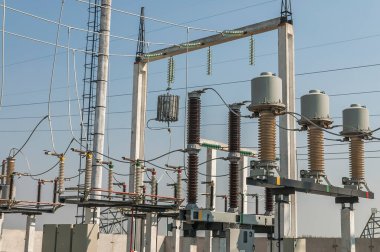 Part of high-voltage substation on blue sky background with switches and disconnectors. Ukrainian energy infrastructure.