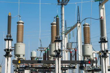 Part of high-voltage substation on blue sky background with switches and disconnectors. Ukrainian energy infrastructure.