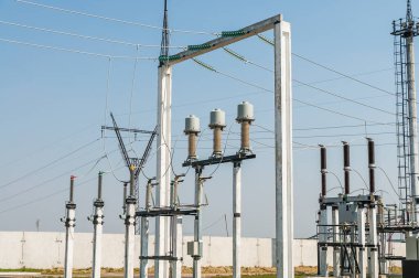 Part of high-voltage substation on blue sky background with switches and disconnectors. Ukrainian energy infrastructure.