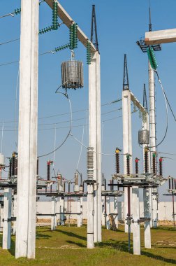 Part of high-voltage substation on blue sky background with switches and disconnectors. Ukrainian energy infrastructure.