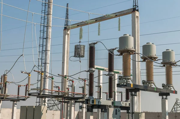 Part of high-voltage substation on blue sky background with switches and disconnectors. Ukrainian energy infrastructure.