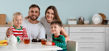 Mutfakta kahvaltı yapan mutlu bir aile.