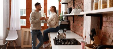 Mutfakta şampanya içen mutlu çift.