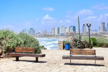 Deniz kıyısındaki bankları olan dinlenme yeri manzarası