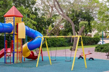 Kentte kaydırak ve salıncaklı çocuk parkı manzarası