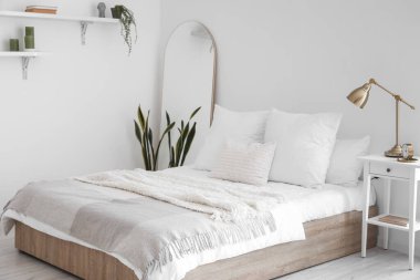 Büyük yataklı, masalı ve aynalı aydınlık yatak odasının içi