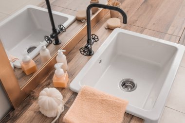 Banyo aksesuarları, lavabo ve ayna ışık duvarının yanındaki masada.