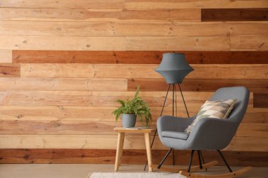 Gri koltuğu, masası ve lambası olan rahat oturma odasının içinde.