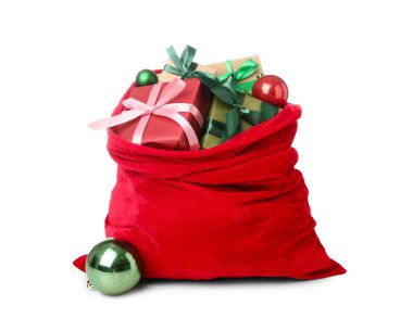 Beyaz arka planda hediyeler ve dekorasyonlarla dolu Noel Baba çantası.