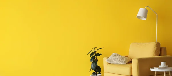 黄色のアームチェア テーブル 観葉植物とテキストのためのスペースと黄色の壁の近くのランプ付きのリビングルームのインテリア — ストック写真