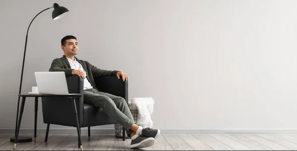 Young Man Sitting Black Armchair Light Wall Space Text — Stock Photo, Image